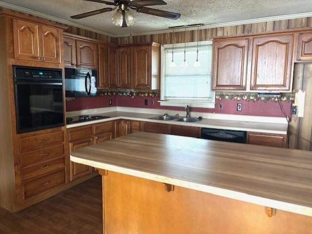 kitchen featuring dark wood-type flooring, sink, crown molding, a textured ceiling, and black appliances