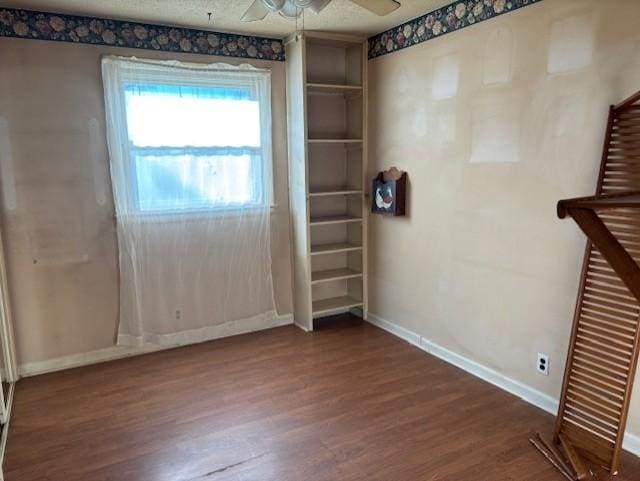 spare room featuring ceiling fan, dark hardwood / wood-style floors, and a textured ceiling