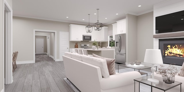 living room with sink, crown molding, a fireplace, and light hardwood / wood-style floors