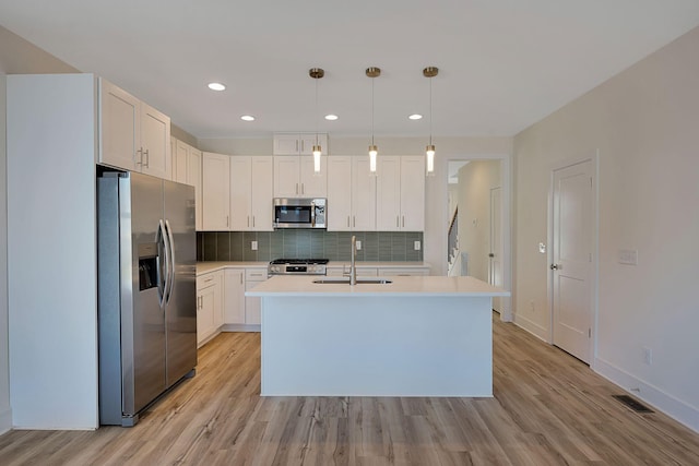 kitchen featuring stainless steel appliances, a sink, visible vents, light countertops, and backsplash