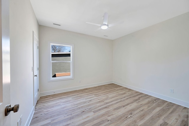 spare room with light wood-type flooring, baseboards, visible vents, and ceiling fan