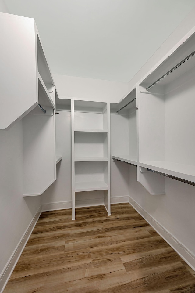 walk in closet with wood finished floors