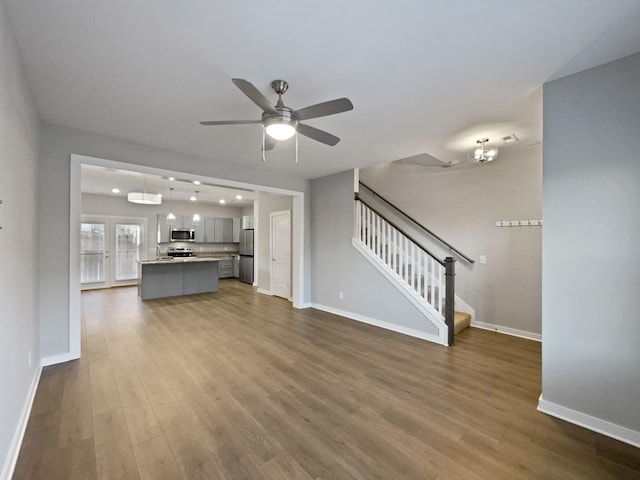 unfurnished living room with wood-type flooring and ceiling fan