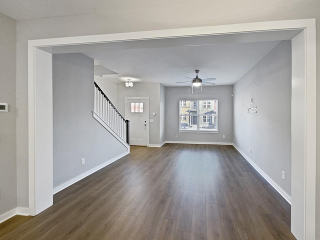 unfurnished living room featuring ceiling fan and dark hardwood / wood-style flooring