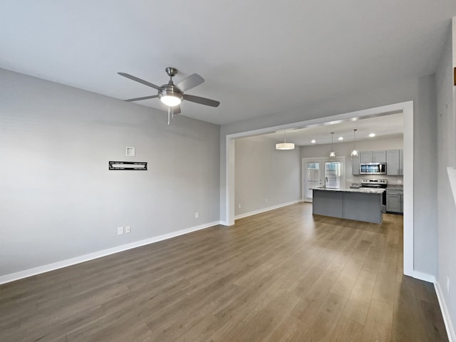 unfurnished living room with hardwood / wood-style floors and ceiling fan