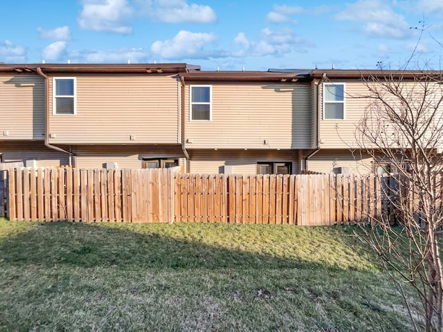 rear view of property featuring a lawn