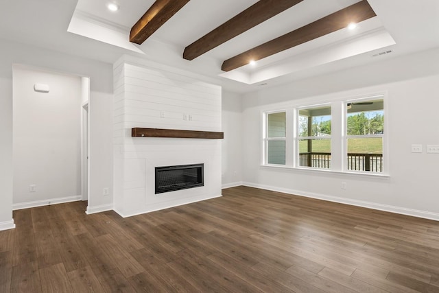 unfurnished living room with beam ceiling, a large fireplace, and dark hardwood / wood-style floors