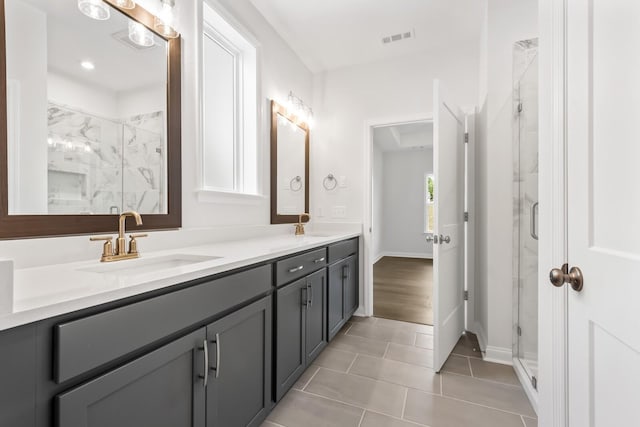 bathroom with an enclosed shower, vanity, and tile patterned flooring