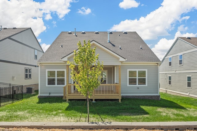 back of house featuring a lawn and central air condition unit