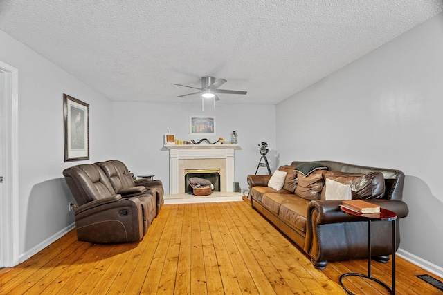 living room with hardwood / wood-style floors, a textured ceiling, and ceiling fan