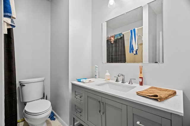 bathroom featuring vanity, curtained shower, and toilet