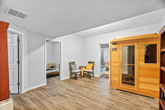 sitting room featuring light hardwood / wood-style flooring and a textured ceiling