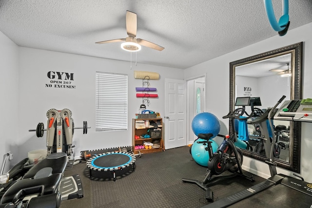 workout room with ceiling fan and a textured ceiling