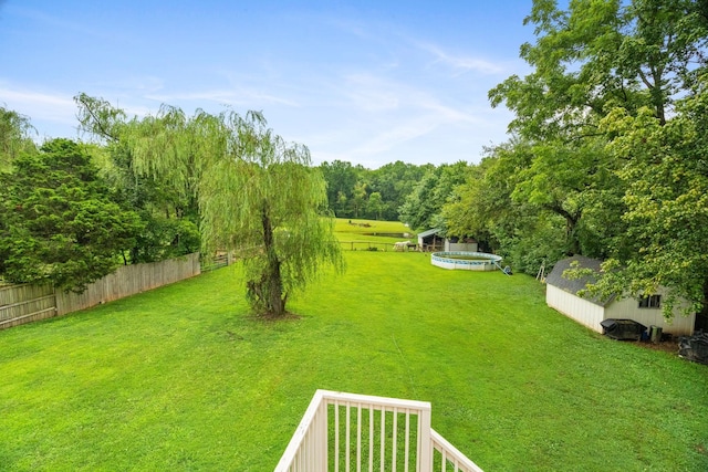 view of yard featuring a pool and a storage shed