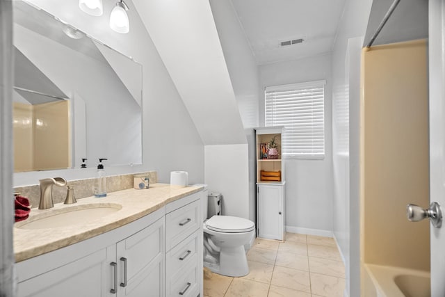 bathroom featuring vanity, vaulted ceiling, and toilet