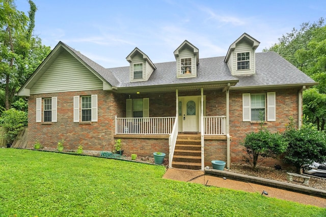 cape cod home featuring a front yard and covered porch