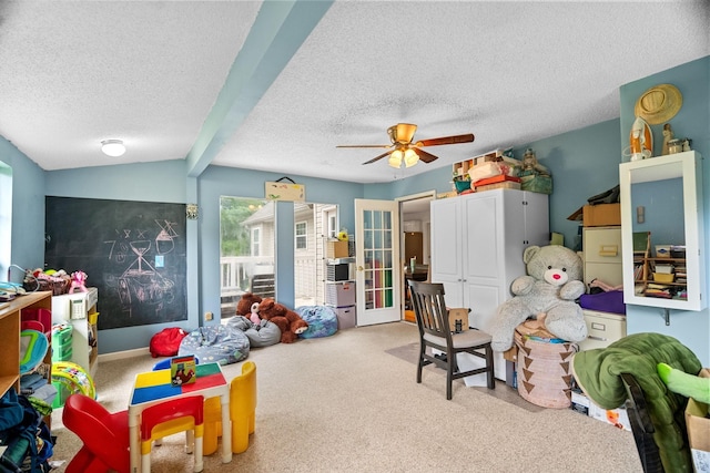 recreation room with lofted ceiling with beams, ceiling fan, carpet, and a textured ceiling