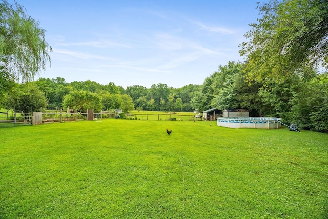 view of yard with a fenced in pool and a rural view