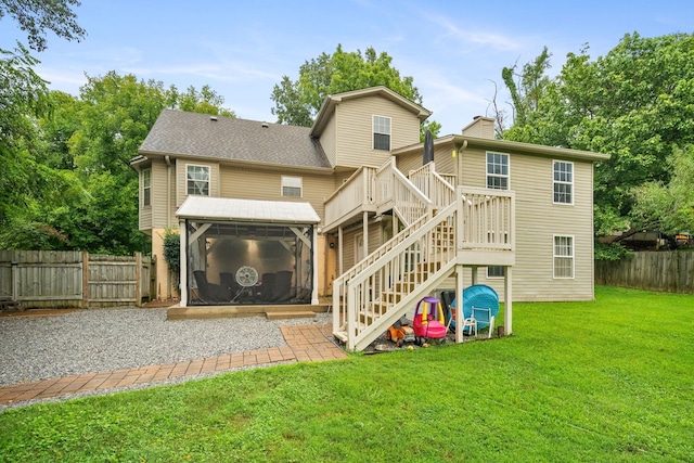 rear view of house with a lawn and a sunroom