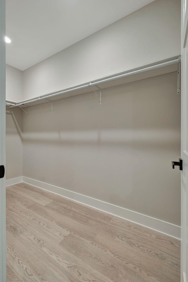 walk in closet with light hardwood / wood-style flooring