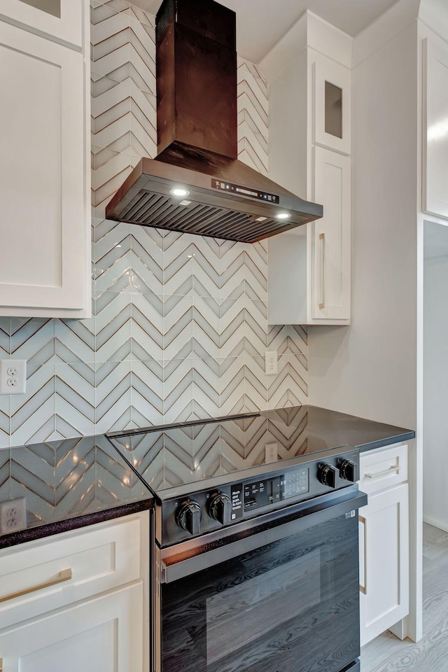 kitchen featuring white cabinetry, black electric range, and exhaust hood