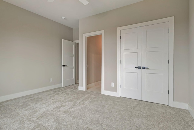 unfurnished bedroom with light colored carpet and a closet