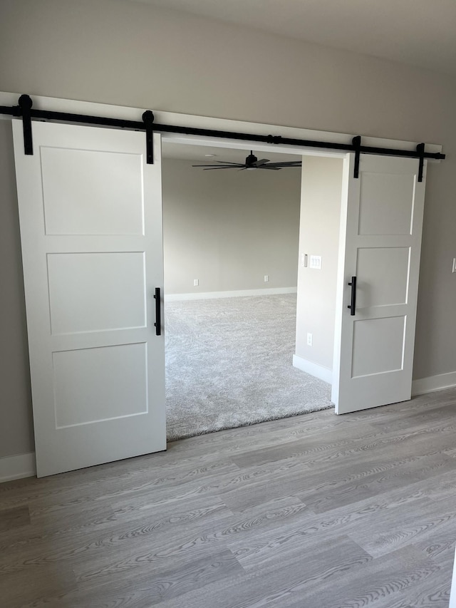 unfurnished room with a barn door and hardwood / wood-style floors