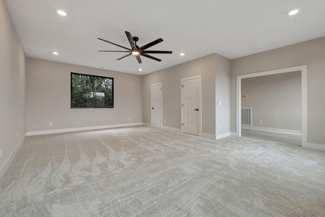 interior space with multiple closets, light colored carpet, and ceiling fan