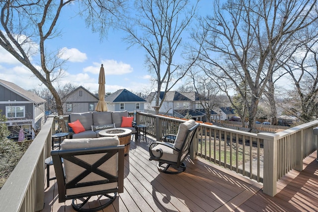 wooden terrace with an outdoor living space with a fire pit