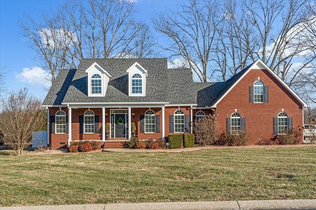 cape cod house with covered porch and a front yard