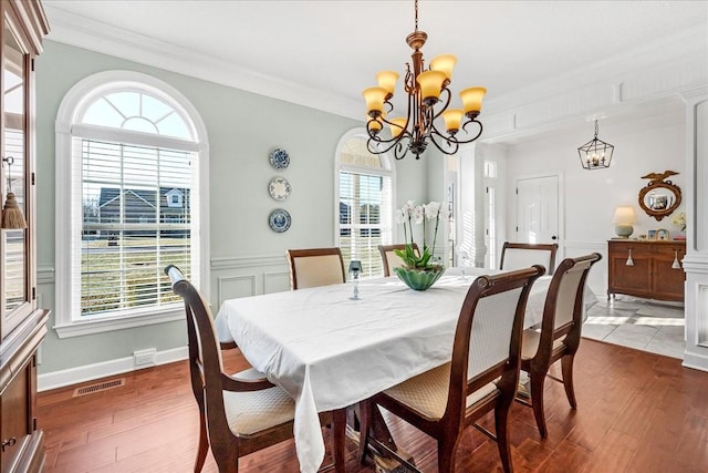 dining space with a notable chandelier, ornamental molding, and dark hardwood / wood-style floors