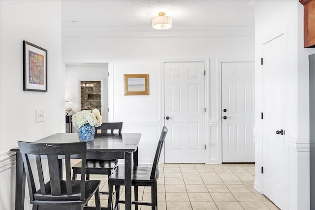 dining room with light tile patterned floors and crown molding