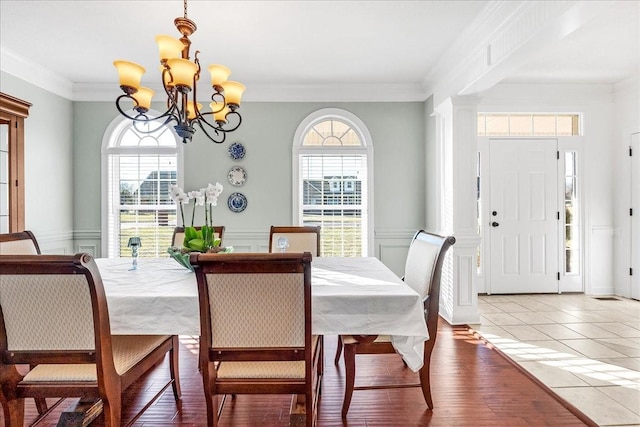 dining room featuring hardwood / wood-style flooring, ornamental molding, and a chandelier