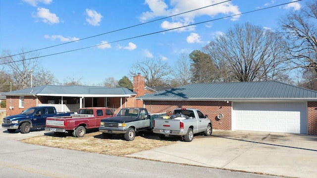 ranch-style home with a garage and an outbuilding