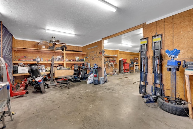 garage with wooden walls, a workshop area, and ceiling fan