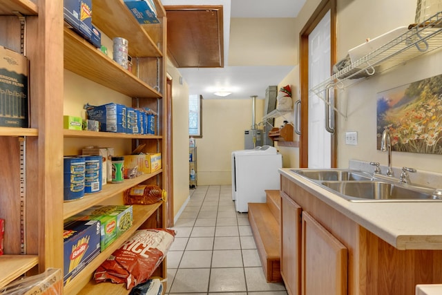 clothes washing area featuring light tile patterned flooring, washer / dryer, and sink