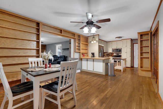 dining space with ceiling fan and light wood-type flooring