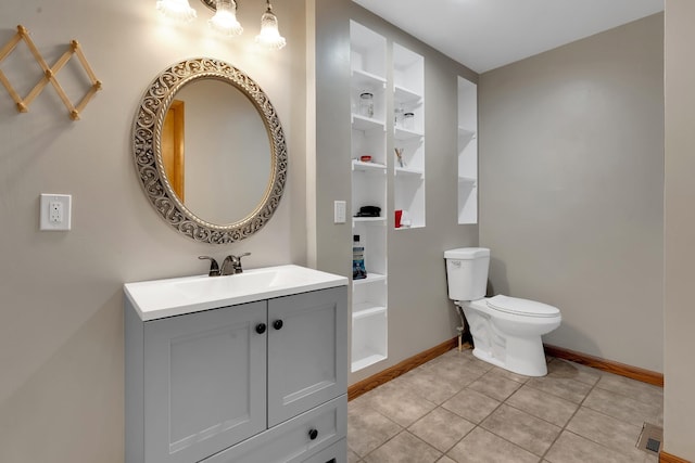 bathroom with tile patterned flooring, vanity, and toilet