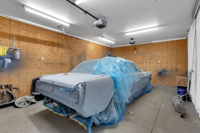 garage featuring a garage door opener and wooden walls