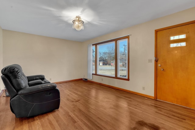 sitting room with a wealth of natural light, an inviting chandelier, and light hardwood / wood-style flooring