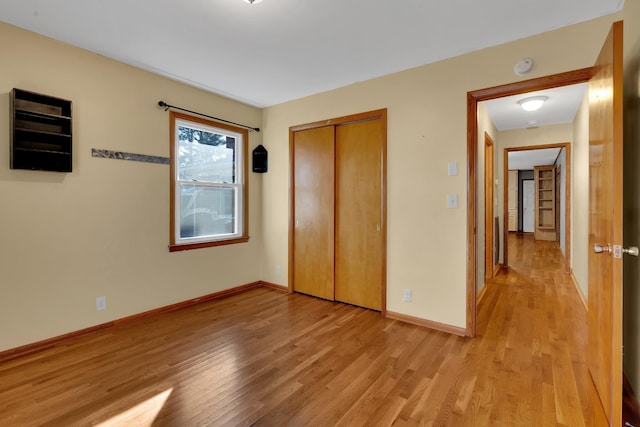 unfurnished bedroom with light wood-type flooring and a closet