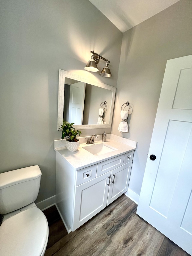 bathroom featuring hardwood / wood-style flooring, vanity, and toilet