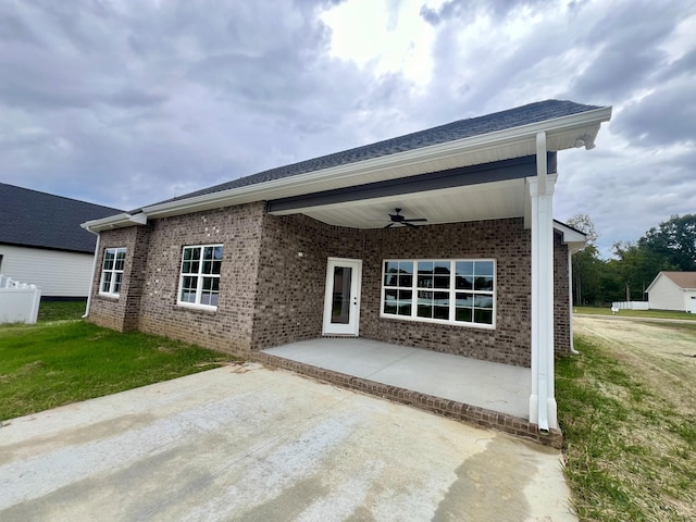 view of front of home featuring a front lawn, ceiling fan, and a patio area