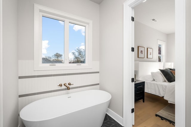 bathroom with hardwood / wood-style flooring and a washtub