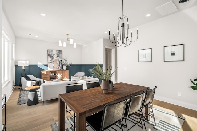 dining area featuring an inviting chandelier and light hardwood / wood-style floors