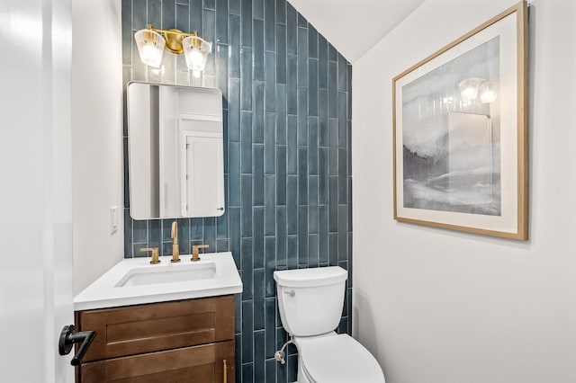 bathroom featuring vanity, toilet, and tile walls