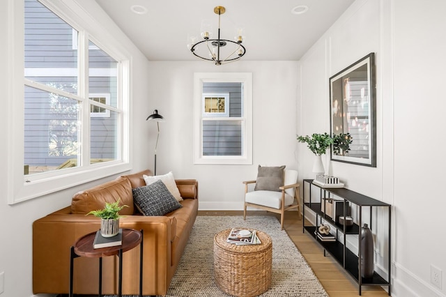 living area featuring a notable chandelier and light hardwood / wood-style flooring