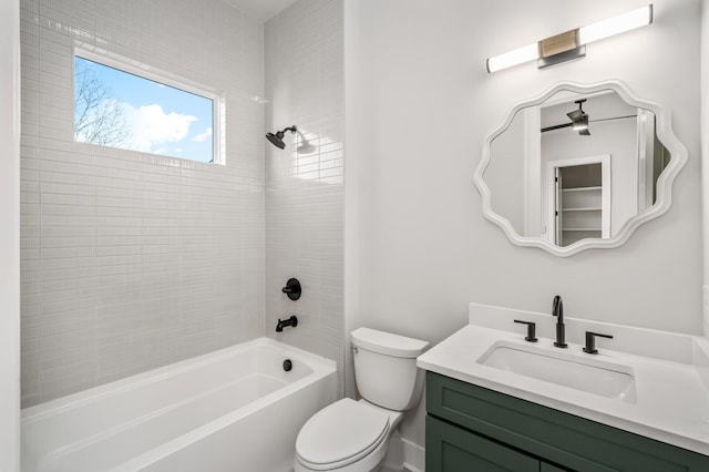 full bathroom with tiled shower / bath, vanity, and toilet