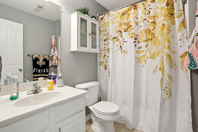 bathroom with vanity, toilet, and a textured ceiling