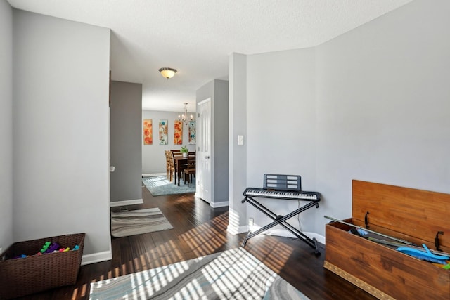 hall featuring dark hardwood / wood-style floors, a chandelier, and a textured ceiling